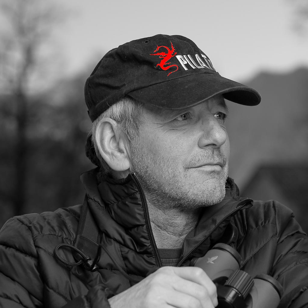 über mich, Daniel Montandon mit Pilatus-Cap auf Fotopirsch mit Feldstecher