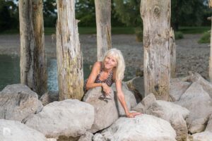 Heidi zwischen Holzpalisaden und liegt auf Blocksteinen am Bodensee