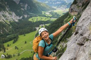 eine Grimasse für den Fotografen mit zugleich einhängen des Karabiners in das Stahlseil